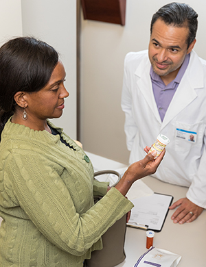 Woman talking to pharmacist at pharmacy counter.