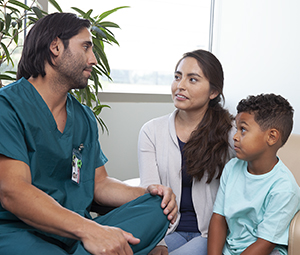 Proveedor de atención médica que habla con un niño y una mujer.